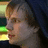 Pixelated image of a person with light brown hair wearing a dark blue beanie, next to blue text on a black background.