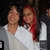 Two people in a close embrace with one person's arm around the other's shoulder, wearing gray and white clothing with red hair visible.