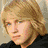 A pixelated image of a person with blonde hair and blue eyes, wearing a black top over red clothing, next to text reading 'hes like this but more lasagna ish.'