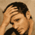 A person with dark hair and light skin appears in two side-by-side frames, hands raised near the head against a beige background.