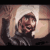 Animated sequence of a figure with a white turban and dark clothing performing repeated hand gestures against a warm-toned background.