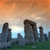 Pixelated landscape showing stone structures under an orange-hued sky with a bright light source behind them.