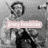 A grayscale pixelated image shows a figure with a circular head and dark clothing holding a light pink rectangular object with indistinct text.