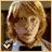 A pixelated image of a person with light brown hair and fair skin, wearing a light blue top with dark accents.