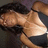 Pixelated image of a person with dark hair lying on their side, wearing a light-colored top and dark shorts against a muted background.