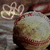A round, light brown object with red stripes sits on a gray fabric background beneath a glowing white 'G' symbol.