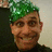 Pixelated close-up of a person with green hair wearing a dark top against a light background.