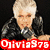 A person with short light hair in a black leather jacket holds a microphone, with text reading "Ojivia975" in red and purple backgrounds.