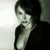 Static grayscale pixelated image of a person with short dark hair wearing a dark jacket over a light shirt, positioned against a gradient background transitioning from white to gray.