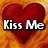 Red heart with text 'Kiss Me' on top-left, 'In' on top-right, and 'The Rain' on bottom-left over orange flame-like background.