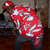 A person in a red cap and red-and-white striped shirt bends forward, viewed from the side with a blurred background.