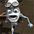 Pixelated cartoon character with large eyes, open mouth, and bow tie, holding a drumstick against dark background.