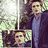 A pixelated image shows a person in a dark jacket and light blue shirt with a black heart symbol above a smaller inset image of the same person.