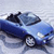 Blue convertible car with dark interior viewed from above on light background, rendered in low-resolution pixel art style.