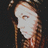Pixelated image of a person with light skin and brown hair against a dark background, showing a partial face and upper body.