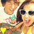 A pixelated image of two people holding a fruit platter with pineapple, watermelon, and other fruits, with a yellow heart symbol in the bottom left corner.