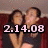 Two people sit on a red couch; one person covers the other's eyes with their hands as the date "2.14.08" appears in pink text.