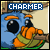 Animated pixel art of a blue creature with orange hands and green collar holding an object, text above changes sequentially from CHARMER to CHARME.