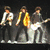 Animated sequence showing three musicians on stage with one in close-up, text 'Jonas Brothers' and four hearts below.