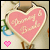 A pixelated heart-shaped icon with pink fill and white outline, featuring a small pink heart in the bottom-left corner and a blue circular element on the left side.