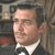 Pixelated portrait of a person in formal attire with a white shirt and black bow tie against a blurred background.