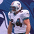 Pixelated image of a football player in white uniform with teal accents and helmet, next to Miami Dolphins logo with orange circle and blue text.