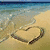 Beach scene with heart drawn in sand, text overlay reading "If the sea washed away your love then it just wasn't meant to be".