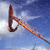 Pixelated static icon of a surfboard-shaped object with gradient colors against a blue sky background, appearing to be a stylized sports or water activity symbol.