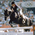 Pixelated static image of a person riding a horse on a racetrack with blurred background elements.