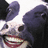 Pixelated cartoon character with large purple ears, white face, dark eyes, and wide red mouth showing teeth.