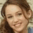 A static close-up of a person with brown hair and light skin smiling, wearing a blue garment against two distinct backgrounds.