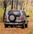 Pixelated image of a silver car with red taillights on a textured background, viewed from the rear with visible headlights and a roof antenna.