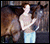 A person in light blue pants stands beside a brown horse, then changes to wearing jeans and a beige top while holding the horse's reins.