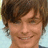 A pixelated image of a person with brown hair and light skin smiling, overlaid with black text reading "he is so hott lets make cookie's ON HIM".