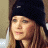 A pixelated image of a person with long light brown hair wearing a black beanie, positioned next to green text reading 'OriginalIcons.com' on a dark background.