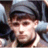 A pixelated close-up of a person wearing a dark cap and light-colored shirt, with a blurred background of indistinct shapes and colors.