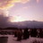 Pixelated static image of a sunset over water with dark silhouettes on the horizon.