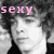 A black-and-white image of a person with curly hair, with pink text reading 'sexy' in the top-left corner.