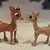 Two brown reindeer face each other on a snowy background with dark trees, while text reads "find love" and "this christmas" in pixelated black-and-white font.
