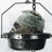 Static pixelated image of a dark-colored helmet with metallic accents inside a transparent dome-like structure.