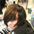 A pixelated image of a person with brown hair and dark clothing, showing text overlays that change across frames.