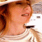 nine pixelated frames showing a person with long red hair wearing a wide-brimmed hat and striped shirt, displaying subtle facial expression changes across the sequence