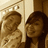 Two pixelated figures in sepia tones stand side-by-side against a light background with vertical lines.