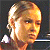 Pixelated close-up of a person with light brown hair and a neutral expression against a dark background.