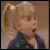 A pixelated image of a young girl with blonde pigtails wearing a blue jacket, next to red and blue text reading "Your in BIG trouble mister!" on a black background.