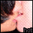 A pixelated image of a person with dark hair and light skin, showing chest area with hands near face, text 'hot' at bottom right.