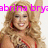 A pixelated image of a woman with long curly blonde hair wearing red earrings and a red-and-black outfit, smiling while raising her right arm.