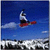 Pixelated image of a snowboarder in mid-air against blue sky with clouds, wearing dark pants and red board.