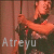 Pixelated static image of a person holding a microphone with text "Atreyu" at the bottom, rendered in warm tones on a brown background.