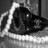 Black-and-white pixelated image of a dark, rounded object with a bright curved highlight on the left side, set against a gradient background.